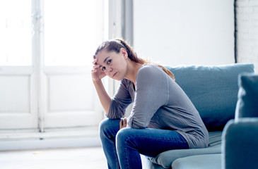 Young attractive latin woman lying at home living room couch feeling sad tired and worried suffering depression in mental health, problems and broken heart concept.