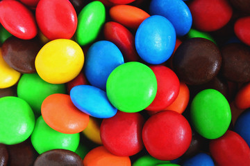 Fototapeta na wymiar Background of colorful button-shaped candies coated chocolate sweets on white background.