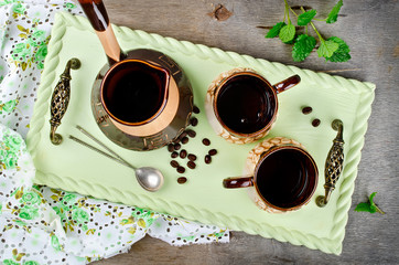 Turk and coffee cups on wooden tray