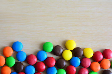 Background of colorful button-shaped candies coated chocolate sweets on white background.