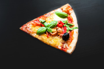 Slice of Italian classic Pizza with pepperoni served on  black background. Flat lay.