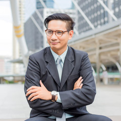 Asia young business man in front of the modern building in downtown .Concept of young  business people