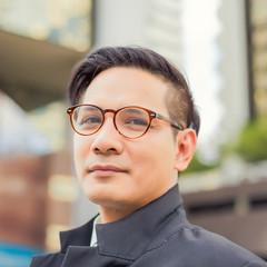 Asia young business man in front of the modern building in downtown .Concept of young  business people