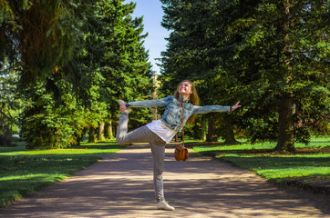 Happy young woman happily posing in a park on a background of trees