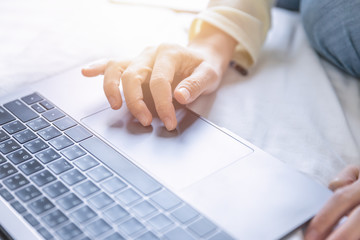 Soft scene of woman hand searching data on internet from notebook computer at home office.