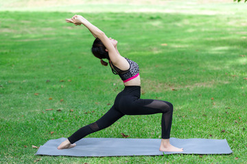 Fototapeta premium Young woman doing yoga in the park