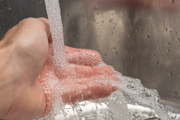 Hand mit Wasser waschen