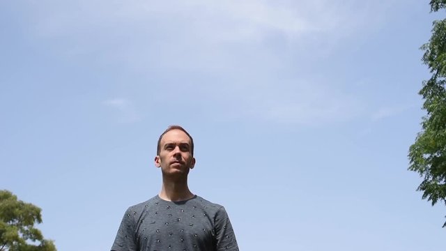 Hombre de frente bajo un cielo azul despejado al aire libre en la naturaleza.