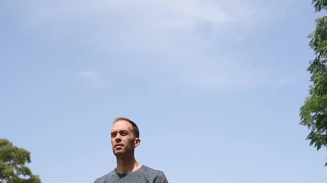 Hombre de frente bajo un cielo azul despejado al aire libre en la naturaleza.
