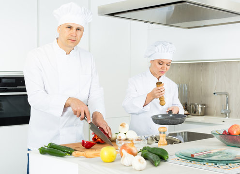 Male cook is making salad on his work place in the kitchen