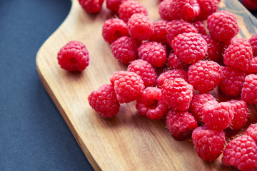Fresh organic raspberries on black background. berries on a wooden spoon