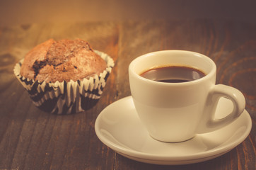 espresso cup and a chocolate muffin/espresso cup and a chocolate muffin on a wooden background, selective focus