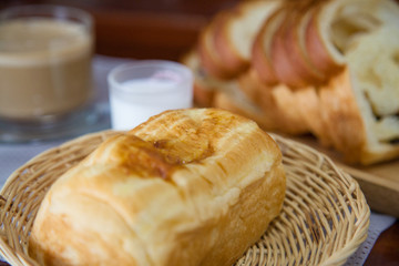 Bread, hot coffee and mike on wooden table.