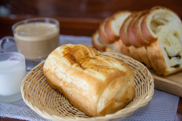 Bread, hot coffee and mike on wooden table.