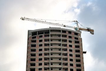 Fototapeta na wymiar The multystoried residential building in the course of construction whith crane.