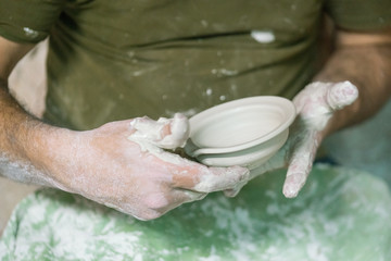 Ceramic dishes in working process. Creating ceramic pieces. Tradicional ceramic factory in spain. man working with traditional potter's wheel