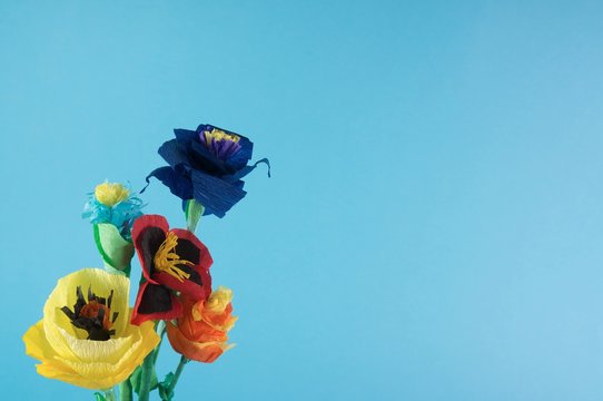 Paper flowers / origami flowers on blue background