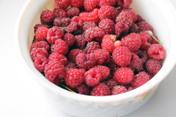 Raspberries in a plate on a white background
