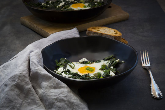 Bowl of green Shakshouka with baby spinach, chard, spring onions and basil