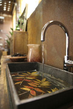 Bathroom sink and stainless steel tap in bathroom with Corten steel wall cladding