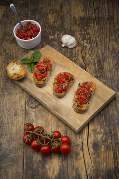 Bruschetta with tomato and basil on wooden board