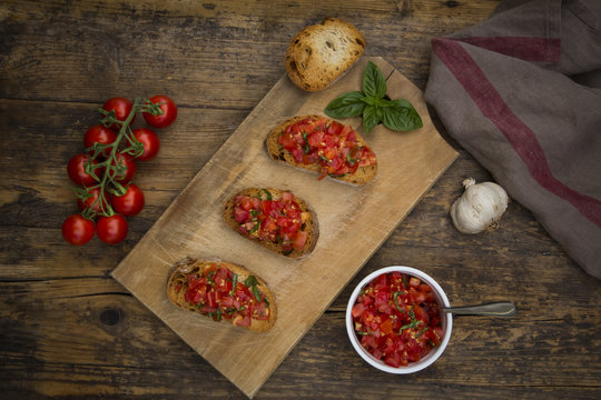 Bruschetta with tomato and basil on wooden board