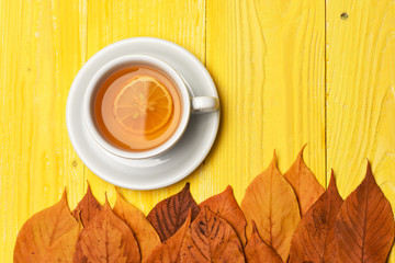 Tea cup with dry leaves making autumn composition