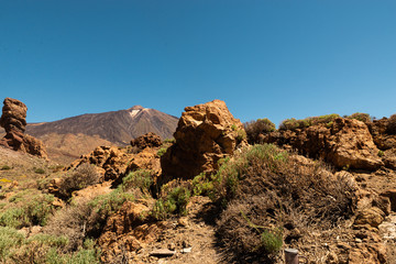 View of landscape of Teide National Park on Tenerife, Canarias islands, Spain. Yellow and black sand and distance view of mountains roads and volcano.