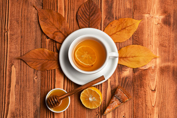 Tea cup with honey, wooden spoon and cake