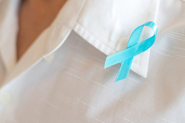 Light blue ribbon awareness on collar of white business male shirt for Men's Health and National Prostate Cancer Awareness Month in September