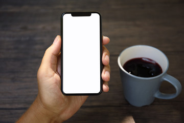 Male hands holding phone with isolated screen over the table