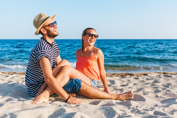 Young couple in love lying on the beach enjoying