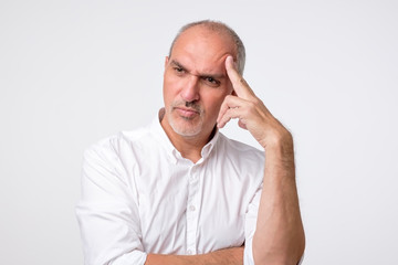 Fototapeta premium mature caucasian man thinking pensive looking up studio portrait. He is trying to make a decision or right choose