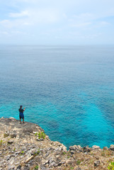 Fototapeta na wymiar Man standing on a cliff in front Sea