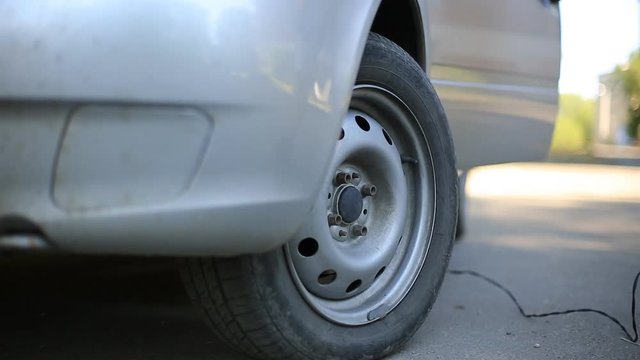 man compressor pump pumps the front wheel of the car.