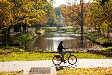 A female cyclist rides a bicycle in the Tiergarten park in Berlin © scharfsinn86