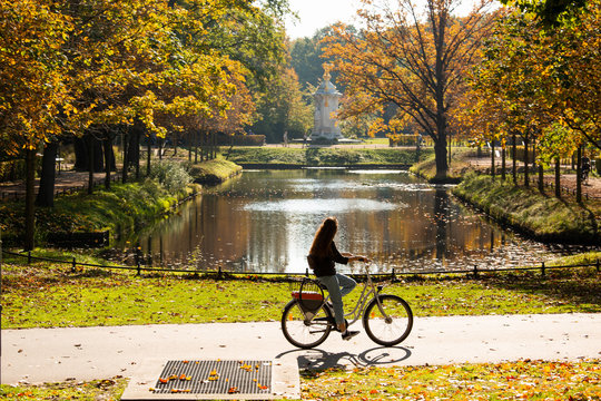 A female cyclist rides a bicycle in the Tiergarten park in Berlin