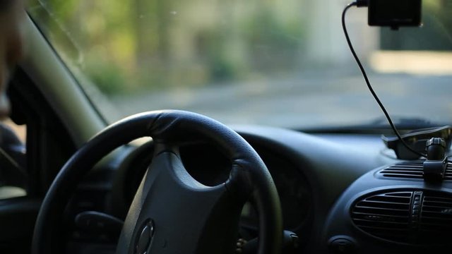 A man gets into the car and turns on the navigator on the smartphone