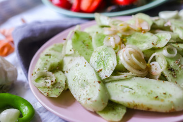Green fresh cucumber salad with onion rings spices, herbs, garlic and unrefined oil. Raw vegan lunch, vegetarian healthy dinner