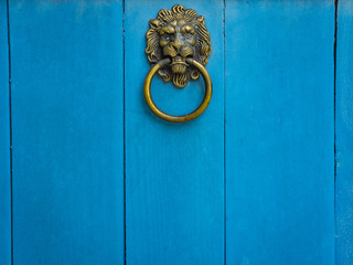 Lion Head Door Knocker on Blue Wooden Door.