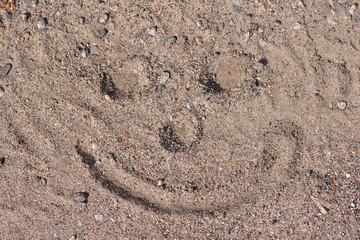 A smiling face inte sand a summer day