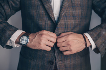 Vintage smart casual outfit outdoor.Fashion model man posing in office.Suited man posing.closeup fashion image of luxury watch on wrist of man.body detail of a business man.Not isolated.