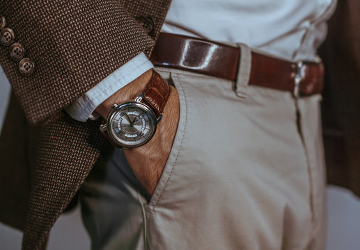 Vintage smart casual outfit outdoor.Fashion model man posing in office.Suited man posing.closeup fashion image of luxury watch on wrist of man.body detail of a business man.Not isolated.