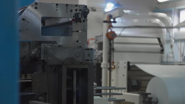 Machinery shop. Punching machine. Die cutting of paper or carton templates for disposable dishes production. Manufacturing from environmentally friendly recyclable materials. Moving parts of mechanism