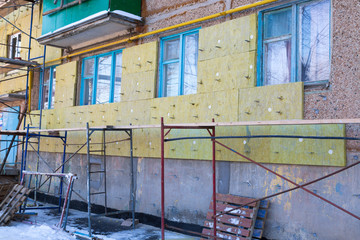 Warming of the apartment house. External repair work on the building, insulation and cladding of the facade of the house
