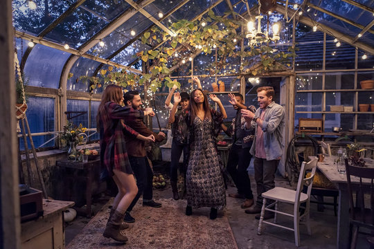 Young people having a party in greenhouse