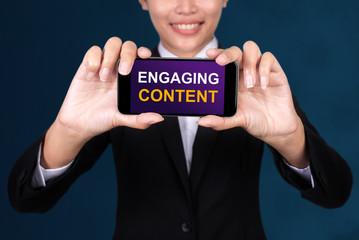 Engaging Content concept, Happy businesswoman Show text Engaging Content on Smart Phone