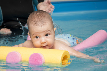 Fototapeta na wymiar Small baby in the kids swimming pool