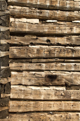 Weathered grungy old log cabin wall with old wooden corner background wallpaper