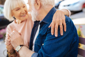 Love in marriage. Selective focus of senior female hand wearing wedding ring and hugging man